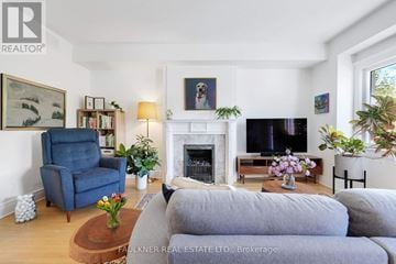 Ottawa condo for rent - A living room with a grey couch, a blue armchair, a fireplace, and a painting on the wall.