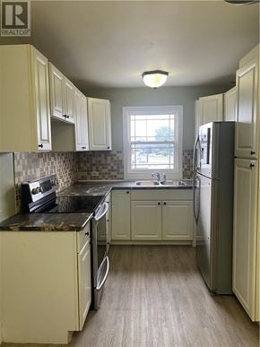 Garson apartment for rent - A kitchen with white cabinets and a black counter top.