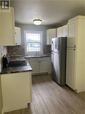 Garson apartment for rent - A kitchen with a refrigerator, cabinets, and a counter.