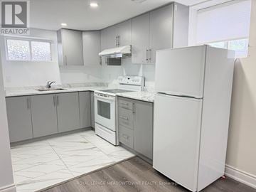 Halton Hills (Georgetown) apartment for rent - A white refrigerator stands in a kitchen with white cabinets and a white countertop.
