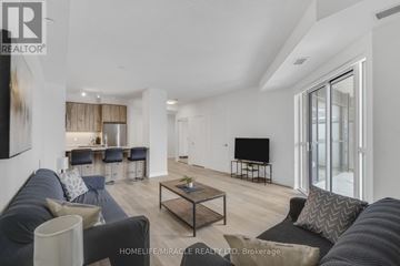 Mississauga (Hurontario) condo for rent - A living room with a grey sofa and a black TV.