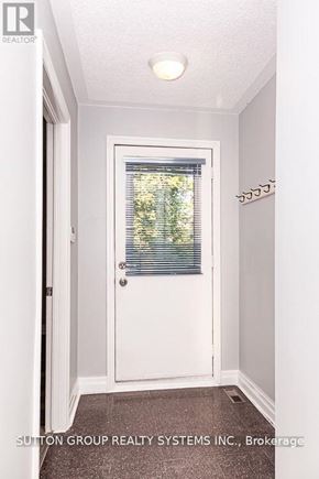 Toronto (High Park-Swansea) apartment for rent - A white door with a window above it in a hallway.