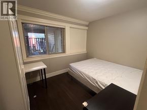 Coquitlam apartment for rent - A bedroom with a bed, desk, and window.