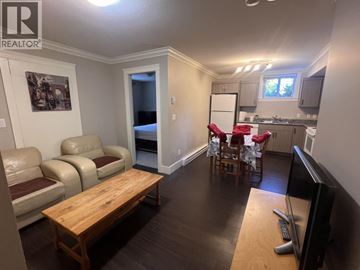 Coquitlam apartment for rent - A living room with a couch, chair, and television.
