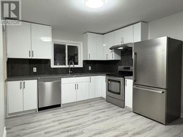 Aurora apartment for rent - A modern kitchen with white cabinets and stainless steel appliances.