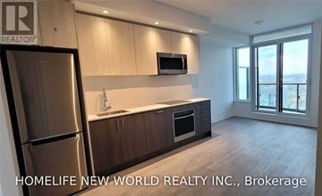 Toronto (South Parkdale) condo for rent - A kitchen with wooden cabinets and a refrigerator.