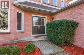 Cambridge apartment for rent - A red brick house with a black door and a small garden in front.