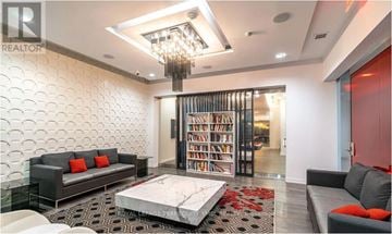 Toronto (Waterfront Communities) condo for rent - A living room with a black couch and a chandelier.