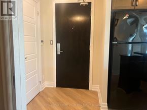 Mississauga (City Centre) condo for rent - A black door in a room with wooden floors and white walls.