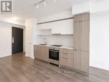 Toronto (Cabbagetown-South St. James Town) condo for rent - A modern kitchen with wooden cabinets and a stainless steel oven.