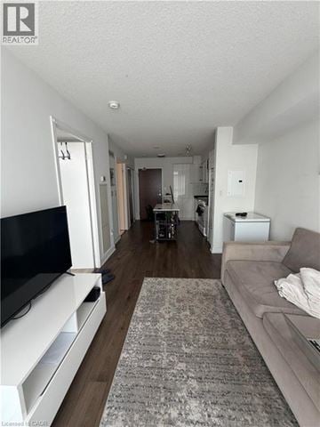 Toronto condo for rent - A living room with a grey couch and a television.