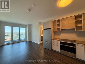 Markham (Commerce Valley) condo for rent - A kitchen with wooden cabinets and a stainless steel refrigerator.