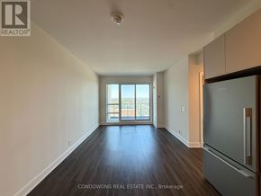 Markham (Commerce Valley) condo for rent - A spacious room with wood flooring and a large window overlooking a balcony.