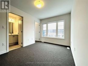 Hamilton (Parkview) townhouse for rent - A spacious room with a carpeted floor and a window overlooking a cityscape.