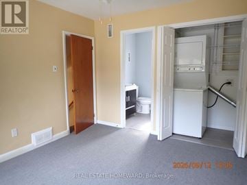 Toronto (Bendale) apartment for rent - A room with a door and a kitchen area with a fridge and a toilet.