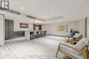 Kitchener condo for rent - A spacious living room with a bar area and a painting on the wall.