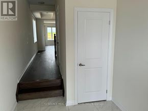 Kitchener apartment for rent - A hallway with a white door and a person standing in the distance.