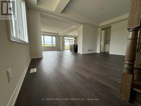Kitchener apartment for rent - A spacious room with wooden flooring and a large window.