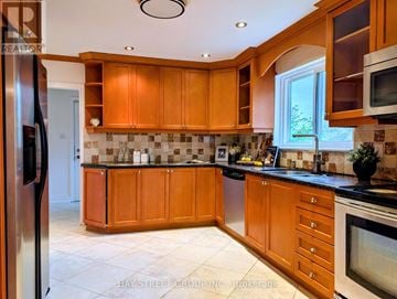 Toronto (Don Valley Village) apartment for rent - A kitchen with wooden cabinets and a black countertop.