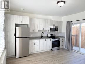 Niagara Falls (Downtown) multi-family for rent - A modern kitchen with white cabinets and stainless steel appliances.