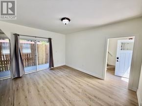 Niagara Falls (Downtown) multi-family for rent - A room with wooden flooring and a sliding glass door leading to a balcony.
