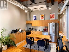 Toronto (Niagara) condo for rent - A modern kitchen with a wooden table and chairs.