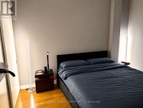 Toronto (Niagara) condo for rent - A bedroom with a bed, nightstand, and lamp.