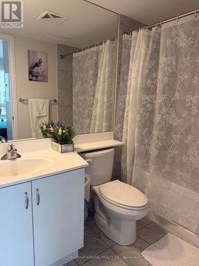 Toronto (Niagara) condo for rent - A white bathroom with a floral shower curtain.
