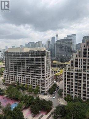 Toronto (Niagara) condo for rent - A cityscape with a large building in the foreground and a cloudy sky above.
