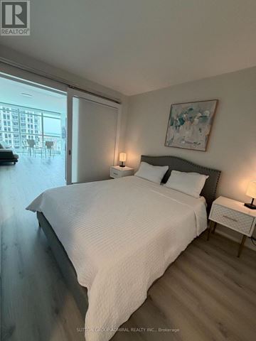 Toronto (Niagara) condo for rent - A bedroom with a large bed and a painting on the wall.