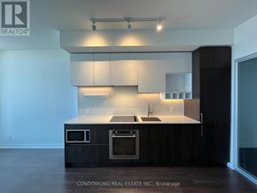 Vaughan (Vaughan Corporate Centre) condo for rent - A modern kitchen with dark wood cabinets and stainless steel appliances.