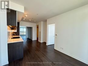 Vaughan (Vaughan Corporate Centre) condo for rent - A modern kitchen with dark wood floors and white walls.