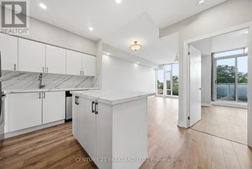 Toronto (High Park North) condo for rent - A spacious kitchen with white cabinets and a wooden floor.