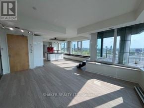Ottawa condo for rent - A spacious room with wooden flooring and large windows overlooking the city.
