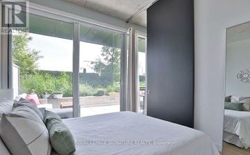 Toronto (Moss Park) condo for rent - A bedroom with a large bed and a view of the outdoors through the windows.