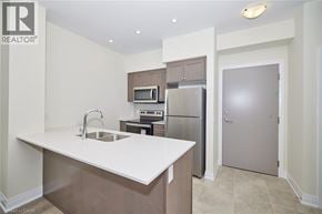 Grimsby condo for rent - A kitchen with a sink, microwave, and refrigerator.