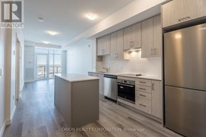 Hamilton (Lakeshore) condo for rent - A modern kitchen with stainless steel appliances and wooden cabinets.