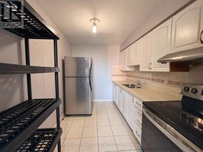 Toronto (Dorset Park) condo for rent - A kitchen with white cabinets and a stainless steel refrigerator.