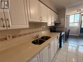 Toronto (Dorset Park) condo for rent - A kitchen with white cabinets and a tiled backsplash.