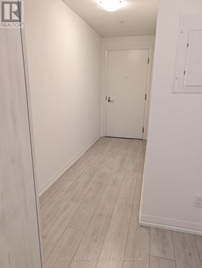Toronto (Waterfront Communities) condo for rent - A white door is in a room with white walls and wood flooring.