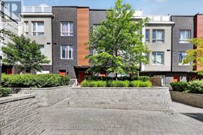 Toronto (Malvern) townhouse for rent - A brick wall separates a courtyard from a building with a red door.