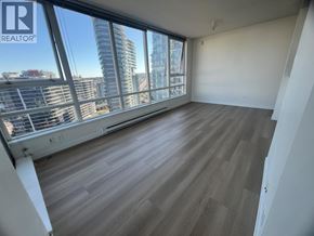 Vancouver apartment for rent - A room with wooden flooring and a large window overlooking a cityscape.