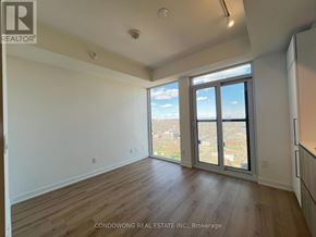 Toronto (Moss Park) condo for rent - A room with wooden floors and a large window overlooking a cityscape.