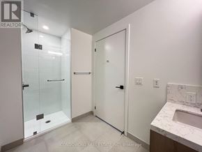 Toronto (Moss Park) condo for rent - A white bathroom with a glass shower door and a white sink cabinet.
