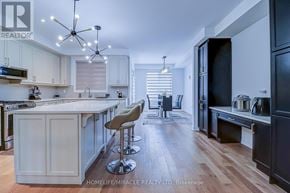 Oakville (Jm Joshua Meadows) townhouse for rent - A modern kitchen with a bar area and a dining area.