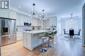 Oakville (Jm Joshua Meadows) townhouse for rent - A modern kitchen with a large island and stainless steel appliances.