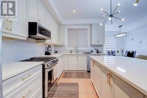 Oakville (Jm Joshua Meadows) townhouse for rent - A modern kitchen with white cabinets and a black stove top.