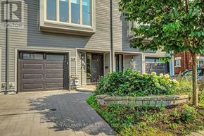 Ottawa townhouse for rent - A house with a driveway and a tree in front of it.