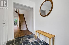 Ottawa townhouse for rent - A hallway with a wooden bench and a mirror on the wall.