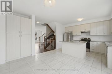 Caledon townhouse for rent - A spacious kitchen with white cabinets and a stainless steel refrigerator.